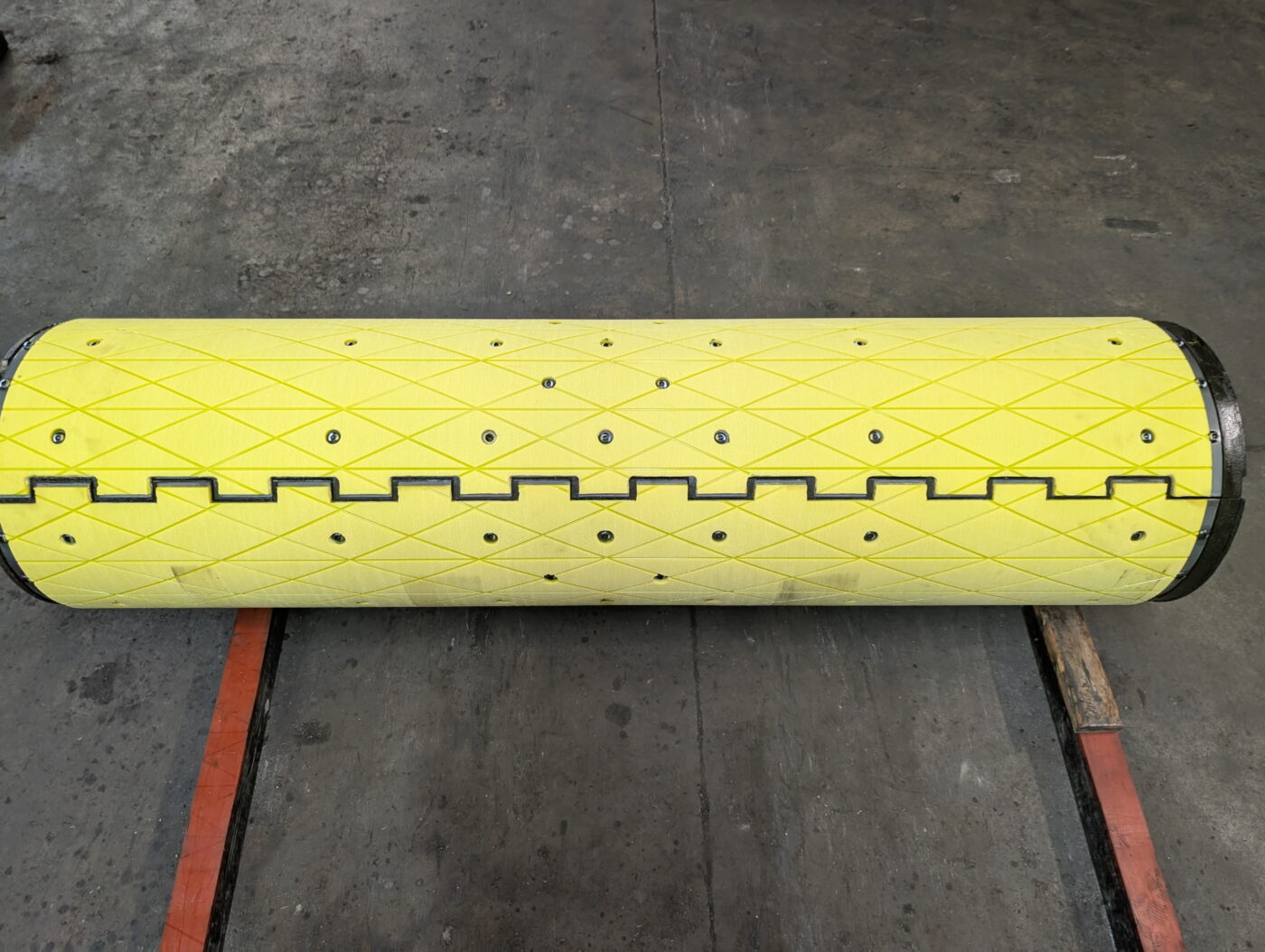 Yellow urethane mandrel segment roller engineered by Universal Urethane Products for industrial coil processing applications.