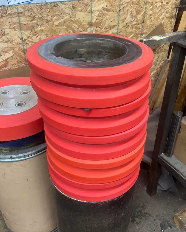 Yellow polyurethane V guide roller with precision-machined metal core used in industrial production lines by Universal Urethane Products.